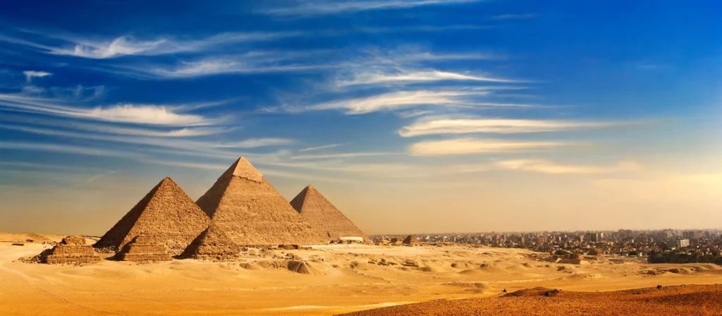 Pyramids of Giza at sunset across the desert