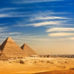 Pyramids of Giza at sunset across the desert