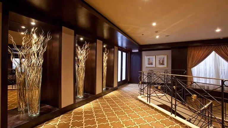 Corridor with lit niche displays and staircase on the Steigenberger Minerva
