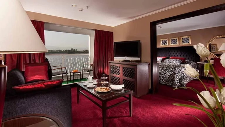 Suite with red sofa and bedroom beyond on the Steigenberger Minerva