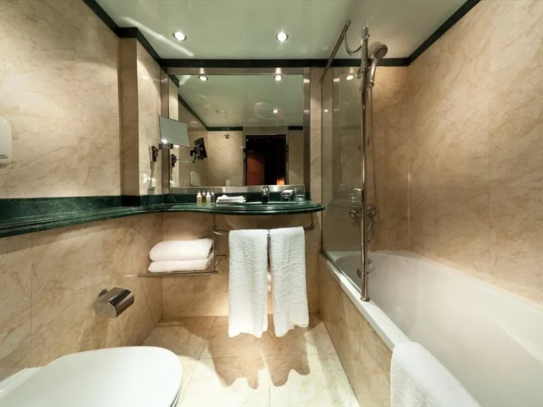 Bathroom with bathtub, marble walls and white towels