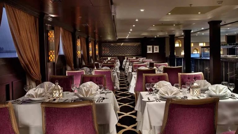 Restaurant with red chairs and set tables on the Steigenberger Minerva