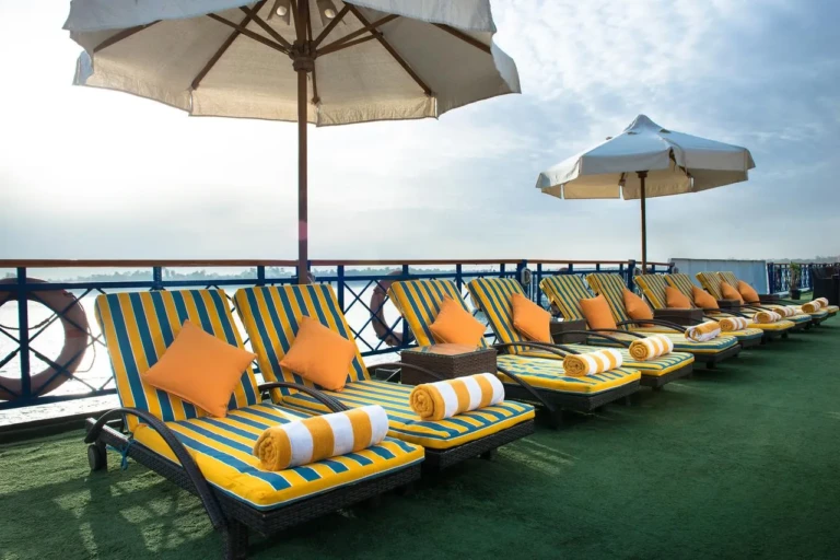 Esmeralda sun deck loungers with striped cushions and umbrellas