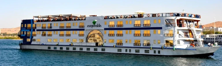 Nile cruise ship with gold-trimmed decks moored on the river