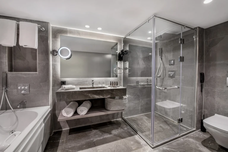 Grey bathroom with bathtub and glass shower on the Historia