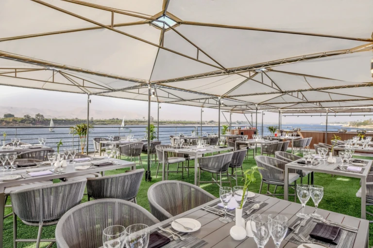 Open-air dining tables under white canopies on the Historia