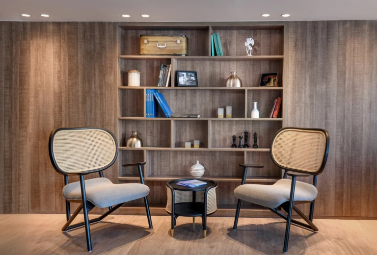 Rattan chairs in front of a wooden bookshelf on the Historia