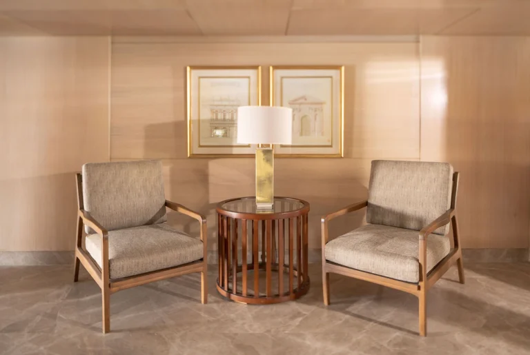Two armchairs and side table with lamp in a hallway alcove