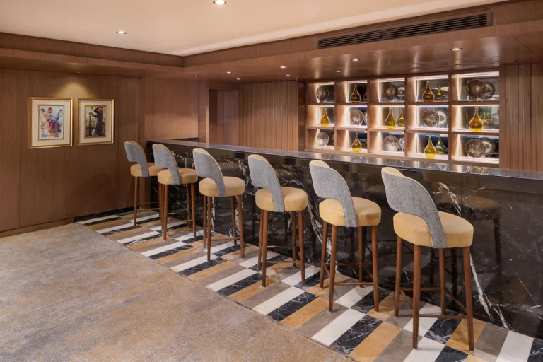 Bar counter with grey stools and display shelves