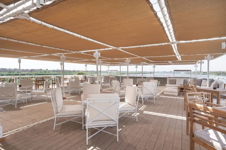 Shaded deck with white chairs under a canvas awning