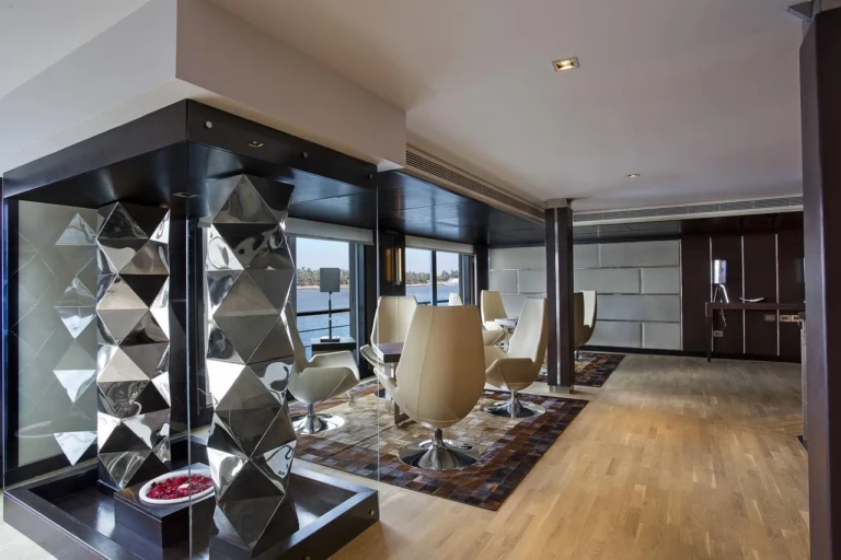 Lounge with mirrored display column and white armchairs on Oberoi Philae