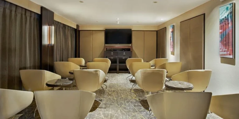 Oberoi Philae lounge with cream armchairs and TV screen