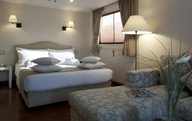 Double bed and chaise lounge in an MS Alexander the Great cabin