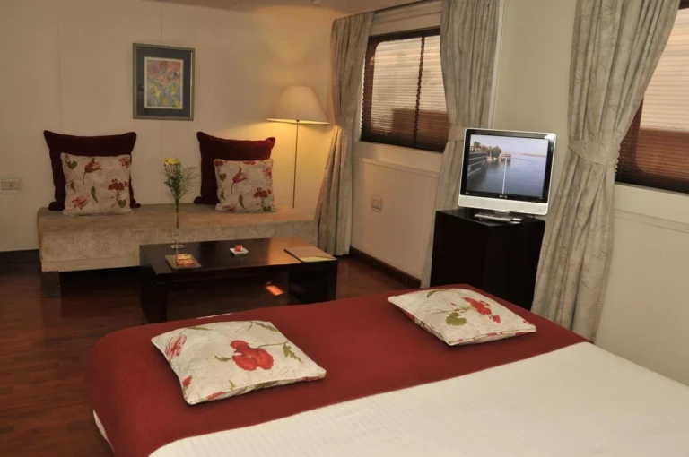 MS Alexander the Great cabin with red bedspread, sofa and TV
