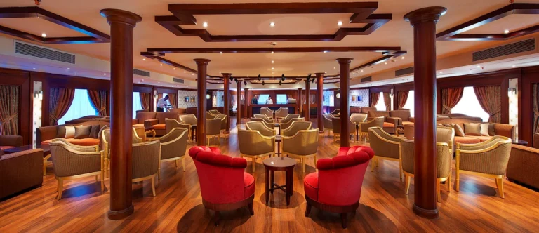 Amwaj Living Stone lounge bar with red tub chairs and columns