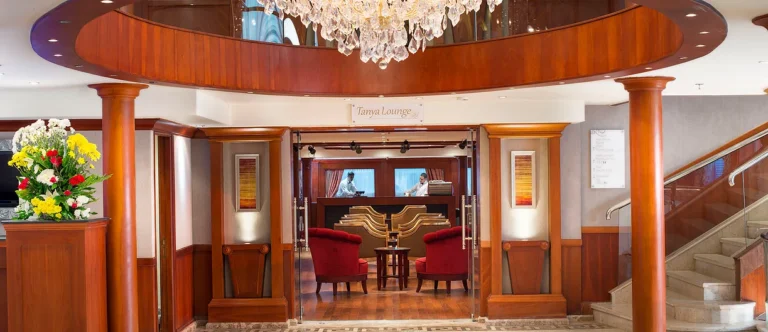 Amwaj Living Stone reception with chandelier and red armchairs