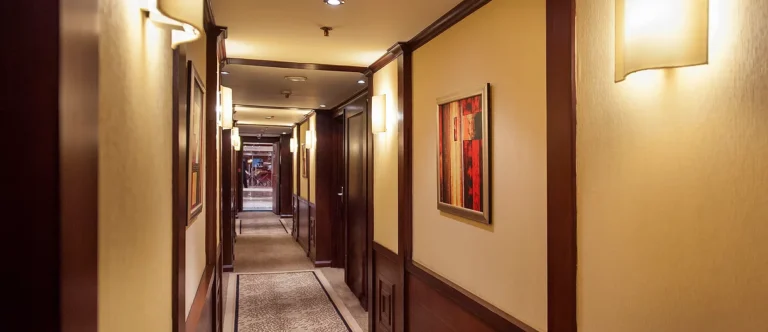 Amwaj Living Stone cabin corridor with wall sconces and artwork