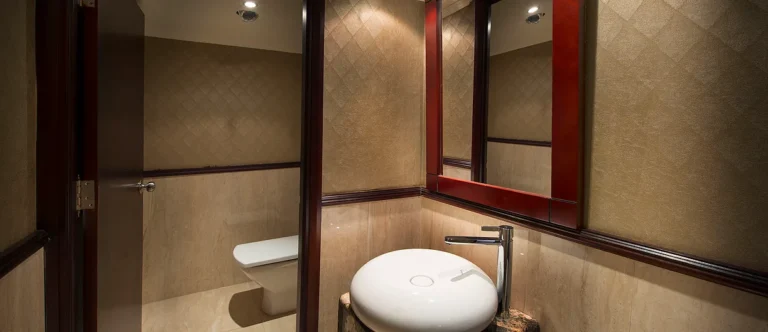 Amwaj Living Stone bathroom with round vessel sink and mirror