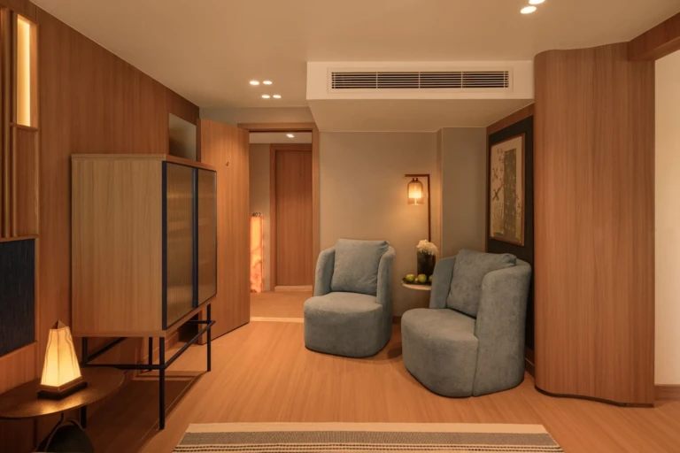 Cabin sitting area with two armchairs and wood panelling on Le Fayan