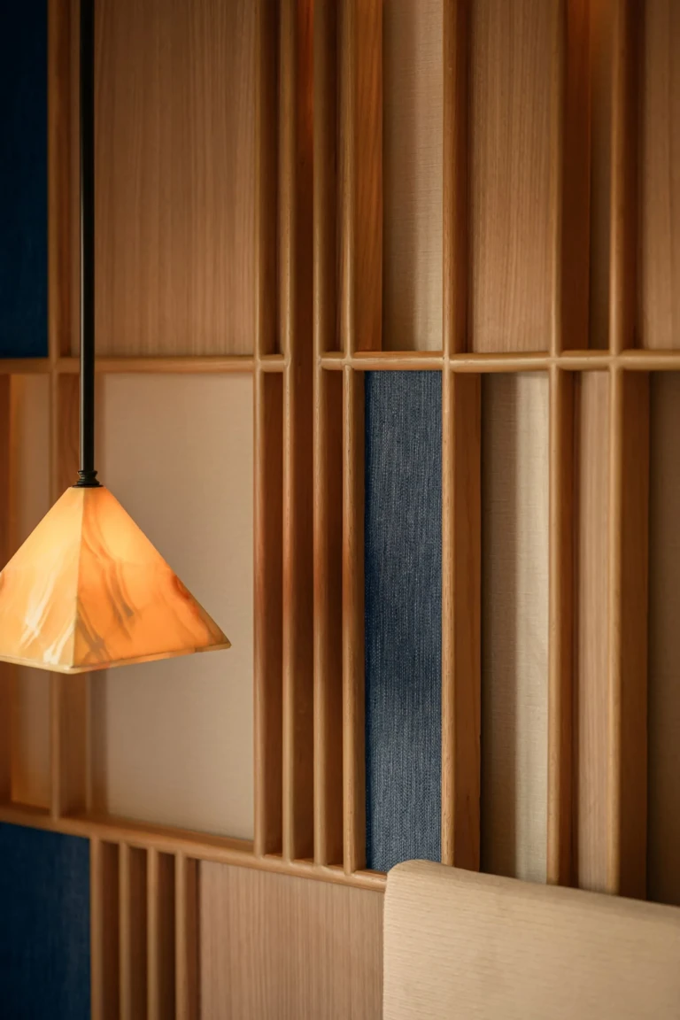Pyramid-shaped pendant lamp against a wooden slatted wall
