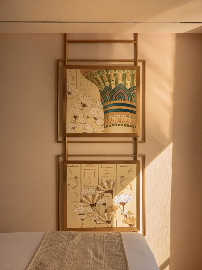 Framed Egyptian lotus and column artwork above a bed