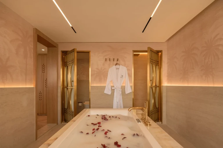 Bathtub with rose petals and hanging bathrobe in a Le Fayan suite