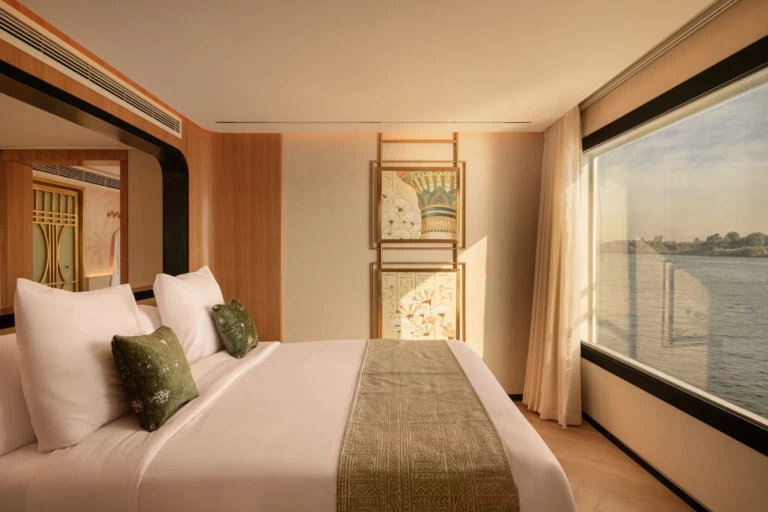Le Fayan cabin bed with green cushions beside a large Nile window