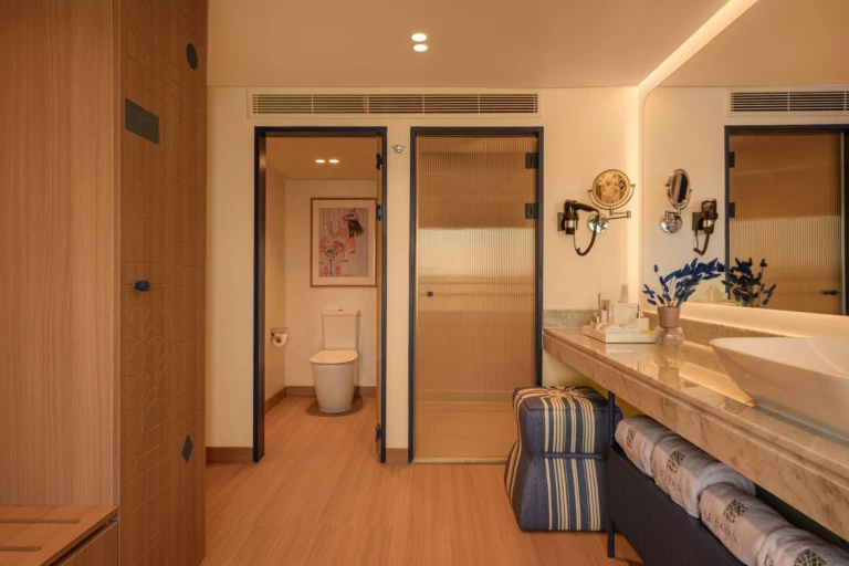Bathroom vanity with open doors to toilet and shower on Le Fayan