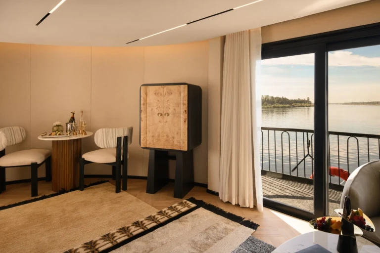 Suite seating area with cabinet and balcony doors on Le Fayan