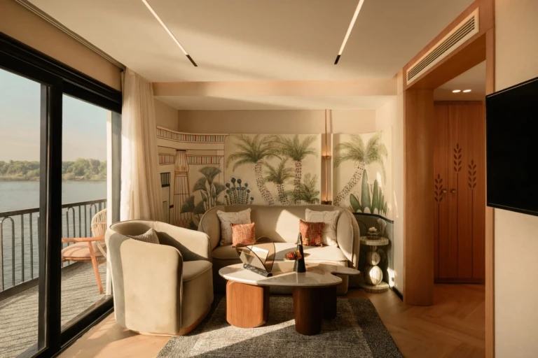 Le Fayan suite sitting area with palm mural and balcony doors