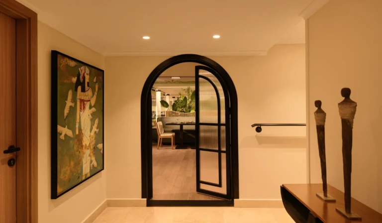 Hallway with arched black doorway and wall art on Le Fayan