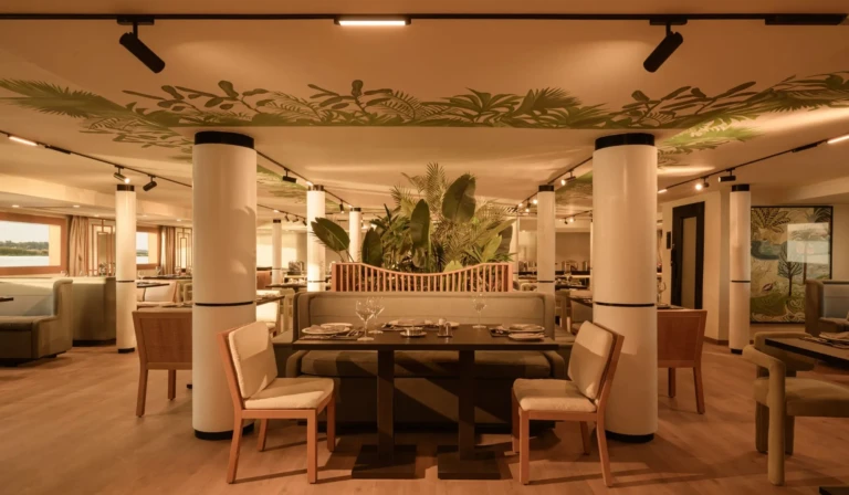 Le Fayan restaurant with set tables and tropical ceiling mural