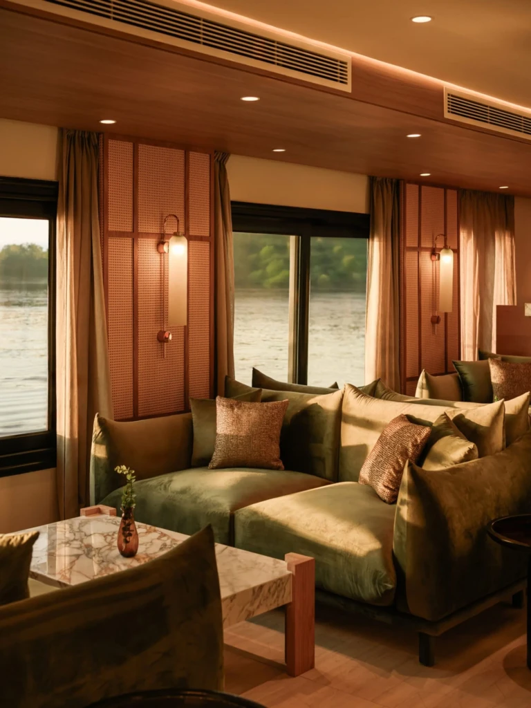 Green velvet sofas by the windows in the Le Fayan lounge