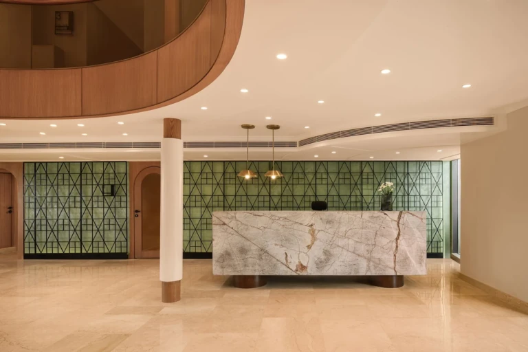 Le Fayan marble reception desk against a green patterned wall