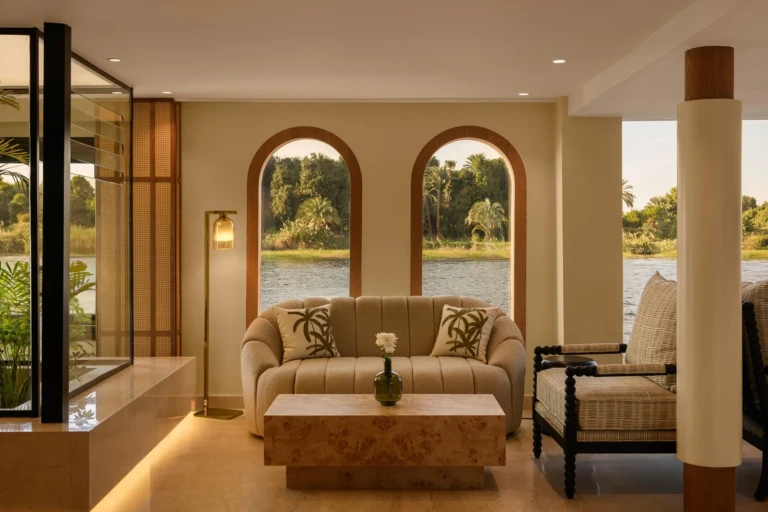Sitting area with sofa and armchair facing arched windows on Le Fayan