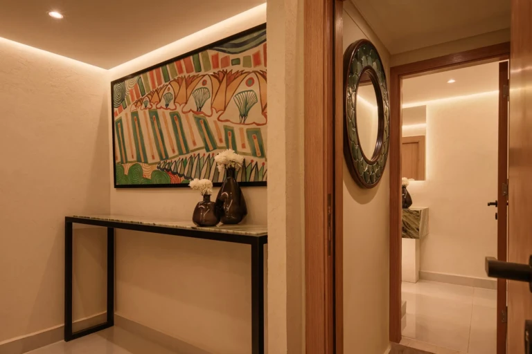 Corridor with framed artwork and console table on Le Fayan