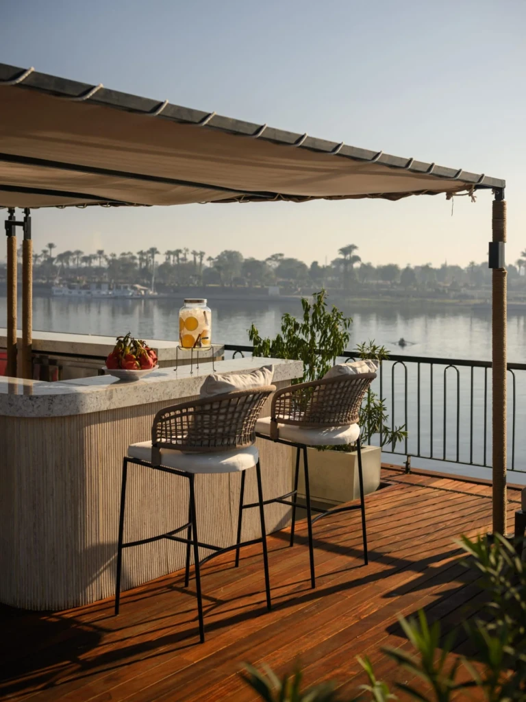 Deck bar counter with two stools facing the Nile on Le Fayan