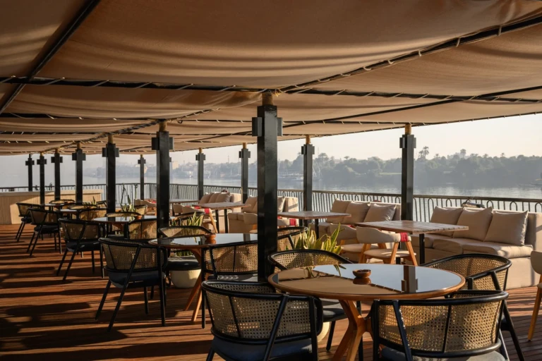 Covered deck restaurant with wicker chairs on Le Fayan