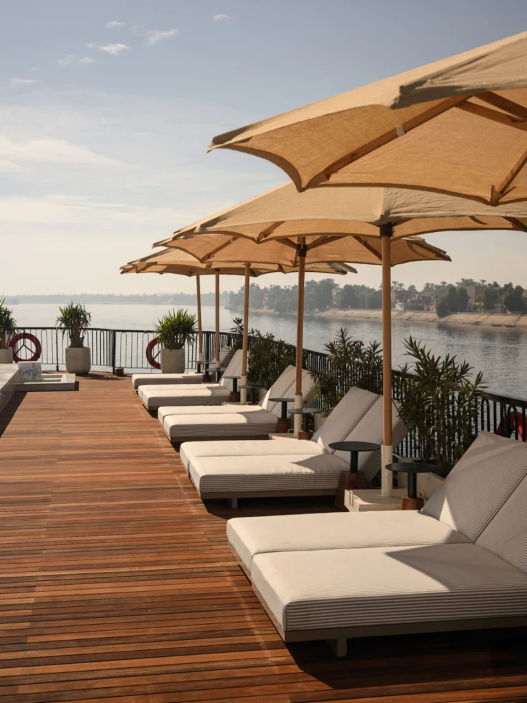 Row of sun loungers and parasols on the Le Fayan teak deck
