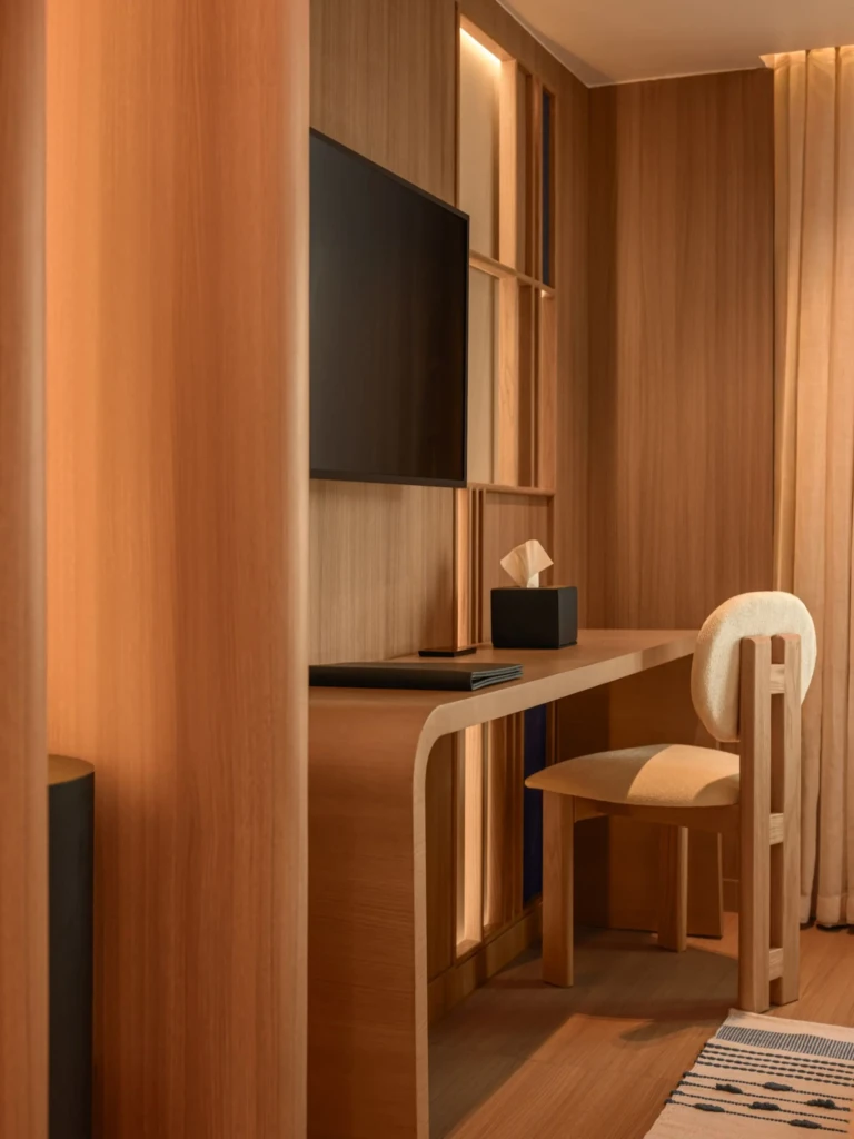 Cabin writing desk with wall TV and chair in warm wood finish