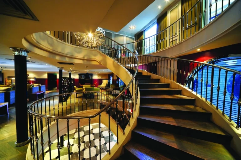 Curved staircase with wrought-iron railing on the MS Mayfair