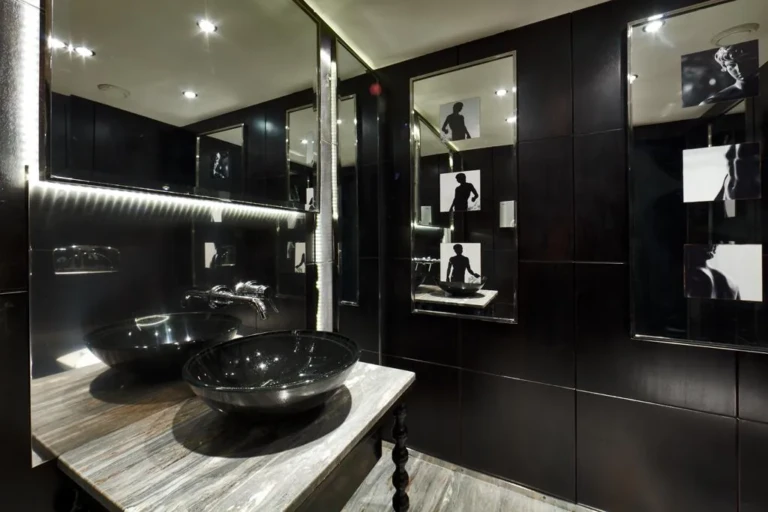 MS Mayfair restroom with black stone basins and framed photos