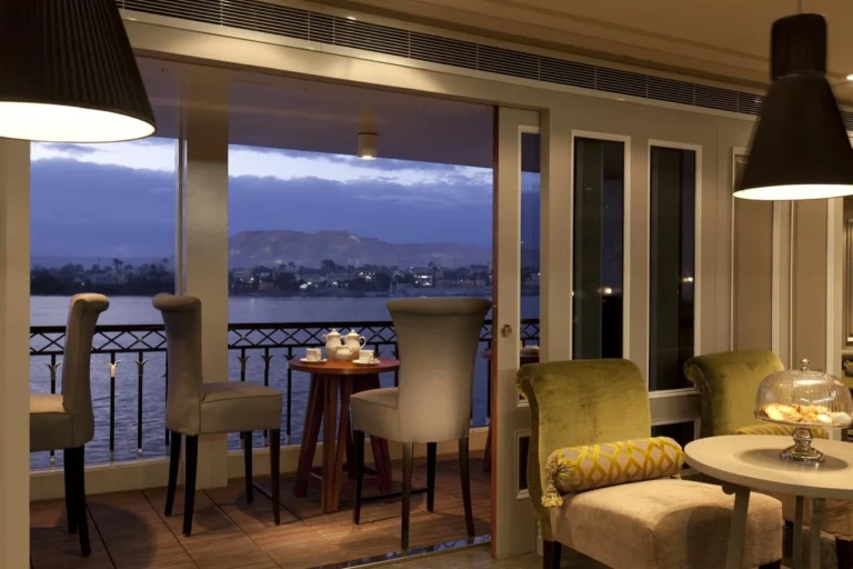 MS Mayfair lounge with armchairs and Nile view terrace at dusk