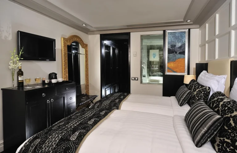 MS Mayfair cabin with twin beds, TV and dark wood dresser