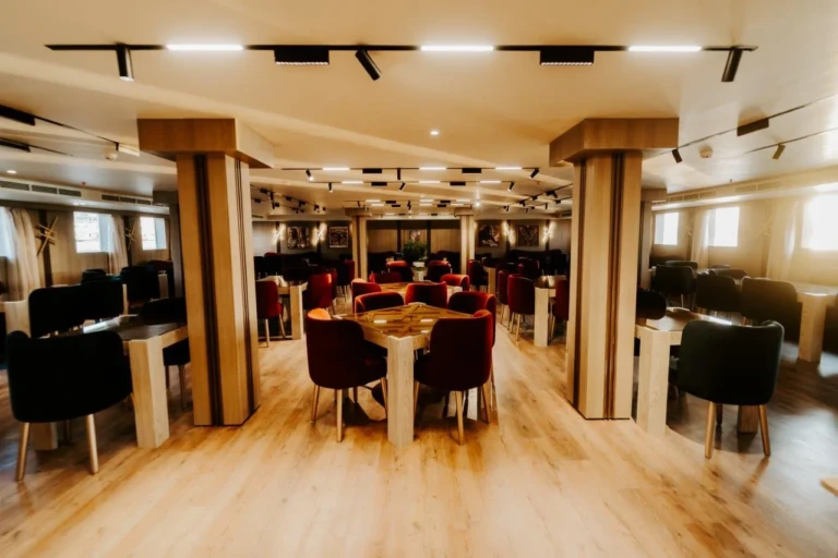 Restaurant with wooden pillars and maroon chairs