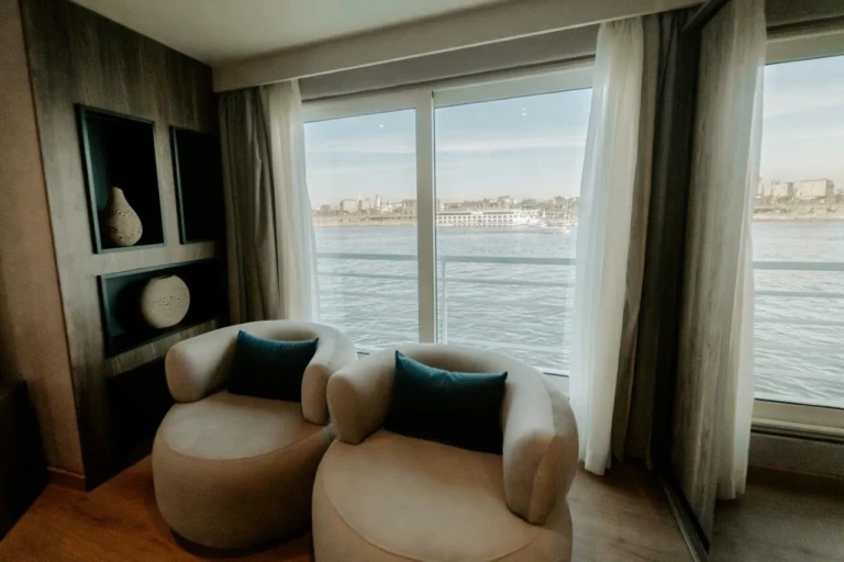 Two armchairs by a panoramic cabin window over the Nile