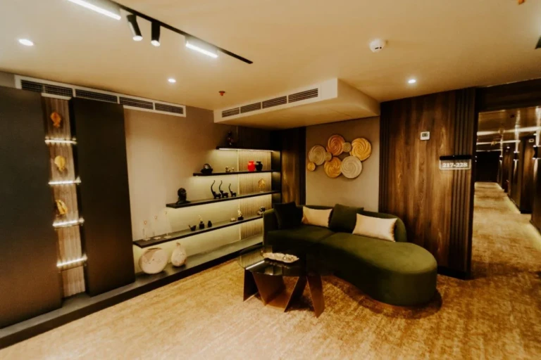 Boutique corner with green sofa and lit display shelves