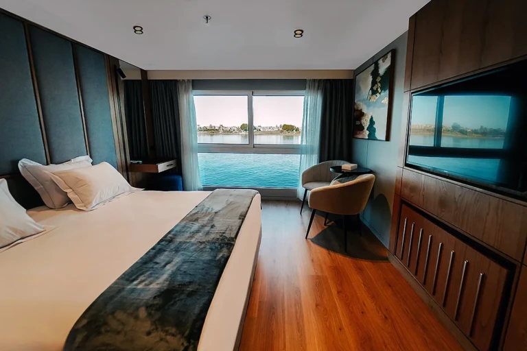 Cabin with double bed facing a river view window on MS Miriam