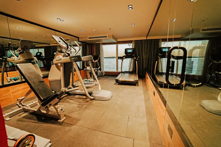 Fitness room with mirrored walls and cardio machines on MS Miriam