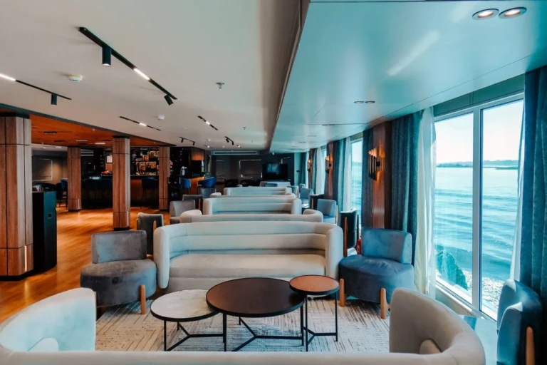 MS Miriam lounge seating beside large river windows